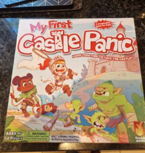 Colorful board game box for "My First Castle Panic," designed for ages 4 and up, featuring children and goblins, emphasizing teamwork in a castle defense theme. Suitable for 1-4 players, it promotes cooperative gameplay.