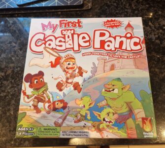 Colorful board game box for "My First Castle Panic," designed for ages 4 and up, featuring children and goblins, emphasizing teamwork in a castle defense theme. Suitable for 1-4 players, it promotes cooperative gameplay.