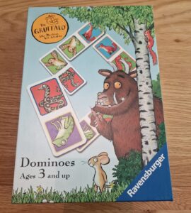 Box of The Gruffalo Dominoes game by Ravensburger, featuring colorful illustrations of animals from the story. Suitable for ages 3 and up, it encourages learning and play.