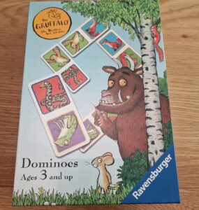 Box of The Gruffalo Dominoes game by Ravensburger, featuring colorful illustrations of animals from the story. Suitable for ages 3 and up, it encourages learning and play.