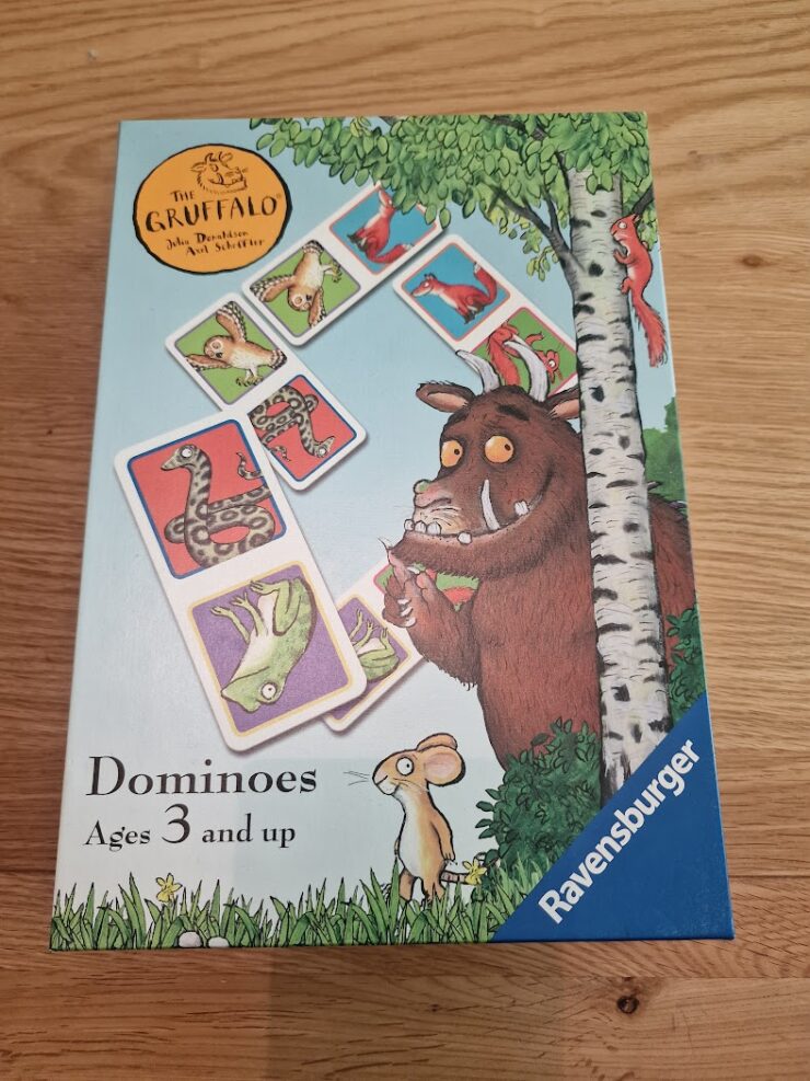 Box of The Gruffalo Dominoes game by Ravensburger, featuring colorful illustrations of animals from the story. Suitable for ages 3 and up, it encourages learning and play.