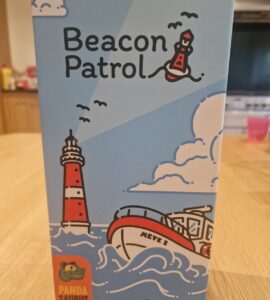 Box design of the board game "Beacon Patrol" by Torben Ratzlaff, featuring a colorful illustration of a lighthouse, a boat named "Meves 2," and playful clouds. The box is branded with the Panda Saurus Games logo, set against a light blue background.