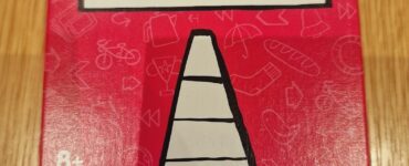Box of the game "That's Not a Hat" by Kasper Lapp, featuring a playful design with a traffic cone illustration on a bright red background. Suitable for ages 8 and up, designed for 3 to 8 players with an estimated playtime of 15 minutes.