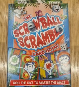 Colorful packaging of "Screwball Scramble" card game featuring playful graphics, instructions to roll dice and navigate a maze, designed for family fun and entertainment.