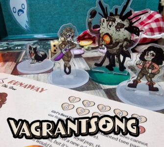 Vagrantsong tabletop game components featuring colorful acrylic character standees, including a dog, a female character with a weapon, and a quirky monster, set against a game board with dice and a character sheet.