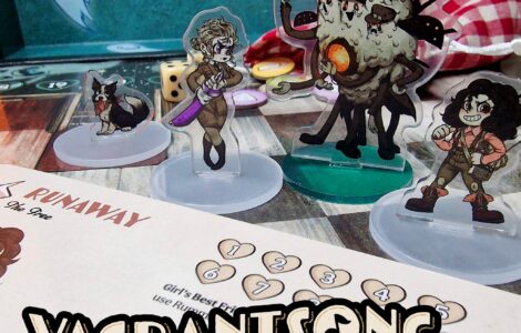 Vagrantsong tabletop game components featuring colorful acrylic character standees, including a dog, a female character with a weapon, and a quirky monster, set against a game board with dice and a character sheet.