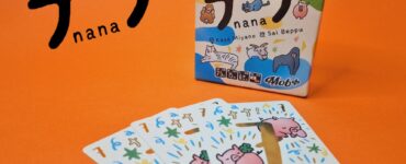 Colorful card game "Nana" by Kaya Miyano and Sai Beppu displayed with its box and several illustrated cards featuring cute animal designs on an orange background.