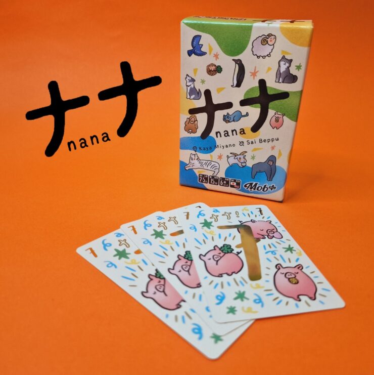 Colorful card game "Nana" by Kaya Miyano and Sai Beppu displayed with its box and several illustrated cards featuring cute animal designs on an orange background.