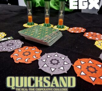 Image of the board game "Quicksand" displayed at EGX, featuring colorful game pieces including hexagonal tokens and hourglasses, highlighting the cooperative gameplay and real-time challenge elements.
