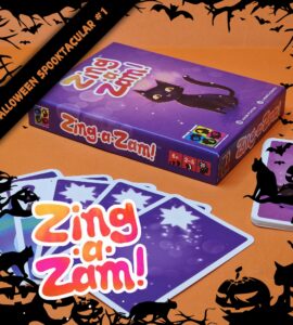 Halloween-themed game "Zing-a-Zam!" displayed with colorful cards and a purple box featuring a playful black cat, suitable for 2-5 players aged 6 and up. Perfect for festive gatherings and family game nights.