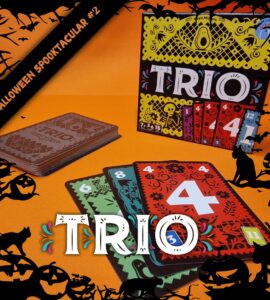 Colorful card game "Trio" displayed on an orange background, featuring a stack of cards and the game box. The cards showcase vibrant designs with numbers, perfect for family game nights. Ideal for ages 7 and up, emphasizing fun and strategy. Halloween-themed decorations enhance the festive atmosphere.
