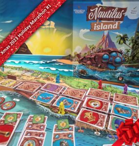 Colorful board game setup for "Nautilus Island," featuring vibrant game pieces on a scenic beach background. The game box displays an illustrated submarine and tropical landscape, with a festive ribbon overlay indicating "Xmas 2023 Holiday Marathon #1." Perfect for family game nights and holiday gatherings.