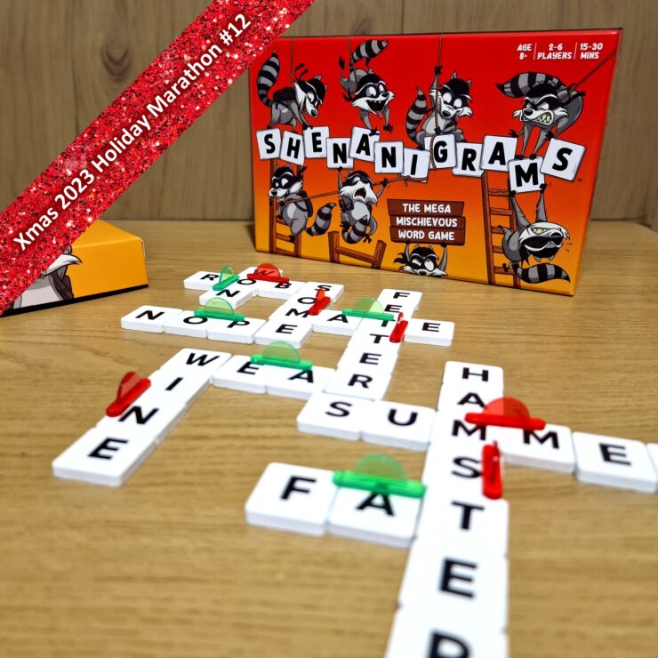 Colorful board game "Shenanigrams" displayed with letter tiles forming words on a wooden table, featuring a playful raccoon theme. Ideal for 2-6 players, ages 8 and up, with a gameplay time of 15-30 minutes. Part of the Xmas 2023 Holiday Marathon.