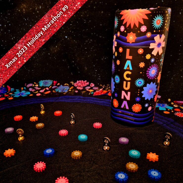 Colorful game pieces scattered on a black fabric surface, featuring the game "Lacuna" prominently displayed. The background showcases vibrant floral designs, and a red banner at the top indicates "Xmas 2023 Holiday Marathon #9." This image highlights a festive and playful atmosphere suitable for game enthusiasts.