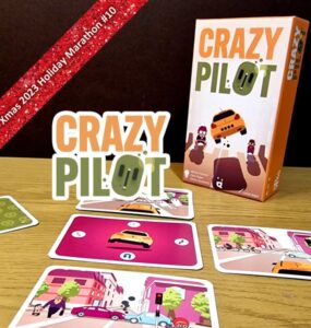 Image of the board game "Crazy Pilot" displayed on a wooden table, featuring the game's colorful box and several gameplay cards illustrating various city scenes with vehicles and pedestrians. The image promotes the Xmas 2023 Holiday Marathon event.