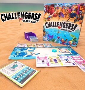 Colorful board game "Challengers! Beach Cup" displayed on sandy beach background, featuring game components like character cards, a scoring sheet, and a card holder. Ideal for family and friends' game nights, emphasizing fun and strategy.