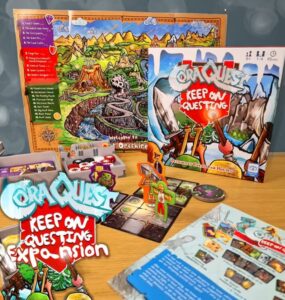 Cora Quest: Keep On Questing expansion game displayed on a wooden table, featuring game board, character tokens, and various game components, highlighting colorful artwork and gameplay elements suitable for family fun.