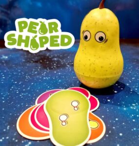 Colorful pear-shaped toy with googly eyes next to vibrant game cards on a starry background, showcasing the playful design of the "Pear Shaped" game.