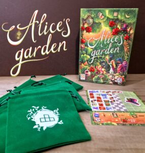 Alice's Garden board game displayed with a colorful box featuring whimsical illustrations, accompanied by several green drawstring bags and game components on a wooden surface.