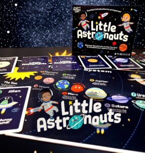 Colorful card game "Little Astronauts" displayed on a cosmic background, featuring planet cards and an illustration of a child astronaut, designed to teach kids about the solar system in a fun and engaging way.
