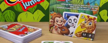 UNO Junior card game packaging displayed with colorful animal-themed cards. The box features characters like a monkey, panda, and giraffe, emphasizing different skill levels for children. The game encourages fun and learning for young players, with a vibrant background of green leaves.