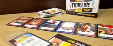 Cooperative card game "Timeline Twist" displayed on a wooden surface, featuring the game box, cards laid out in sequence, and rule booklet. The game encourages teamwork to navigate historical events, suitable for 2-8 players aged 8 and up.