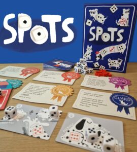 Colorful board game "Spots" featuring dice, action cards, and playful dog illustrations. The image showcases the game components laid out on a wooden surface with a vibrant blue background, highlighting the game's engaging design and mechanics. Perfect for family game night or gatherings.