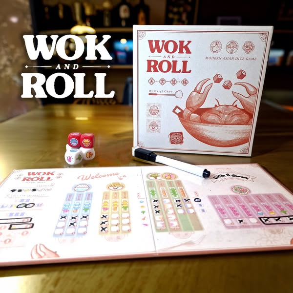 Wok and Roll board game displayed on a wooden table, featuring the game box, colorful dice, and player score sheets. The design highlights modern Asian themes and gameplay elements, suitable for family and friends.