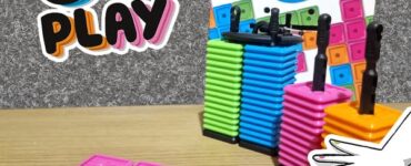 Colorful stacking game "OK Play" featuring vibrant blocks in pink, orange, green, and blue. The game encourages strategic thinking as players aim to connect five blocks in a row. Ideal for 2-4 players aged 6 and up, the packaging showcases the game design and instructions.