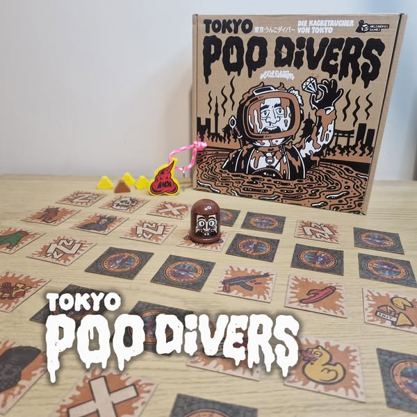 An image depicting the board game "Tokyo Poo Divers," featuring the game box, game pieces, and cards laid out on a wooden surface. The colorful design includes a cartoon diver, playful tokens, and various illustrated cards, showcasing the game's fun and quirky theme.