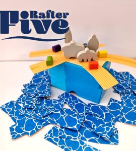 Colorful game setup for "Rafter Five," featuring a blue box with wooden animal figures and vibrant building pieces scattered around.