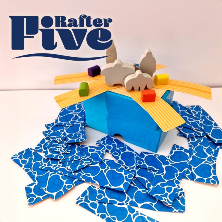 Colorful game setup for "Rafter Five," featuring a blue box with wooden animal figures and vibrant building pieces scattered around.