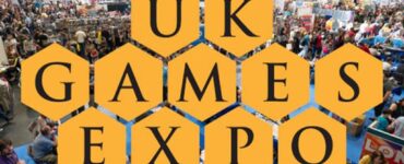 Aerial view of the UK Games Expo showcasing a bustling crowd of attendees engaging with tabletop games and vendors, featuring the event's logo and a "First Time Family Guide" text overlay.