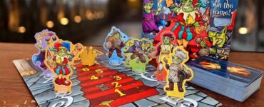 Colorful board game "The Crooked Crown" displayed with character tokens on the game board, featuring vibrant artwork and cards, set against a blurred background. Summer Marathon 2024 branding visible in the corner.