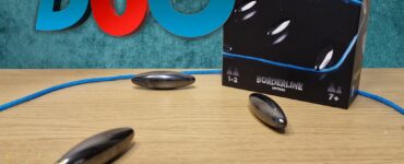 KluSter Duo board game displayed on a wooden table, featuring a colorful box with game pieces and a blue cord, promoting the Summer Marathon 2024 event. Ideal for 1-2 players aged 7 and up, highlighting its engaging gameplay.