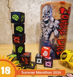 Colorful Zombie Dice and a themed cup are displayed on a wooden surface, featuring various dice with brain, foot, and explosion designs. The image promotes the Summer Marathon 2024 event.