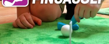 Child playing Fingagolf on a green mat, focusing on putting a white ball into a small hole. The image promotes the Summer Marathon 2024 event, showcasing fun indoor golf activities for kids.