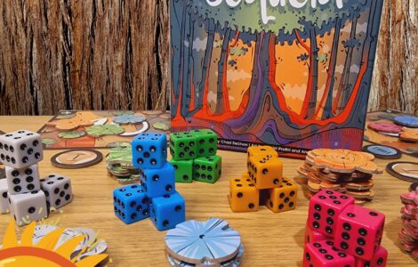 Colorful game components including dice and tokens from the board game "Sequoia" by Chad DeShon, displayed on a wooden table with a background of tree bark. The image promotes the Summer Marathon 2024 event.