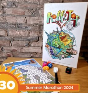 Colorful board game "Roll to the Top" displayed on a wooden table, featuring vibrant artwork and game components including dice and a score sheet, with a brick wall in the background. Ideal for family game nights and gatherings.