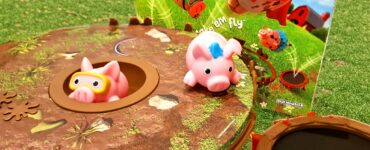 Colorful game setup of "Pigs on Trampolines," featuring two pig figures on a trampoline-like base, with the game box in the background. Ideal for children ages 6 and up, promoting fun and interactive play. Summer Marathon 2024 event branding visible in the corner.