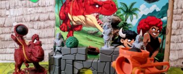Colorful display of the board game "Jurassic Feud" featuring detailed miniature figures and vibrant scenery. The game is currently on Kickstarter, with promotional graphics highlighting a summer marathon event in 2024.
