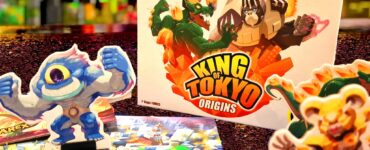 Colorful display of the board game "King of Tokyo: Origins" by Richard Garfield, featuring game pieces, dice, and character standees. The image highlights the vibrant artwork and components of the game, set against a blurred background. Text overlay reads "41 Summer Marathon 2024."