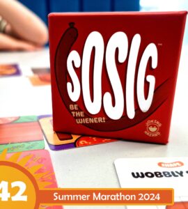 Red box of the game "sOSIG" featuring the tagline "Be the Wiener!" on a table with colorful game cards, hinting at a fun and interactive gaming experience for the Summer Marathon 2024.