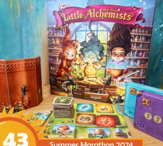 Colorful board game "Little Alchemists" displayed on a wooden table, featuring vibrant artwork of characters engaging in potion-making. The game box, cards, and tokens are arranged alongside a themed background, promoting the Summer Marathon 2024 event.