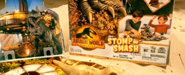 Jurassic World Stomp n Smash game featuring Kinetic Sand, a dinosaur figure, and colorful game board, highlighted for Summer Marathon 2024.