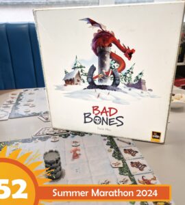 Board game "Bad Bones" by David Flies displayed on a table, featuring a colorful cover with a dragon and snowy landscape. Game pieces and cards are visible on the table, promoting the Summer Marathon 2024 event.