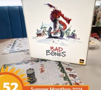 Board game "Bad Bones" by David Flies displayed on a table, featuring a colorful cover with a dragon and snowy landscape. Game pieces and cards are visible on the table, promoting the Summer Marathon 2024 event.