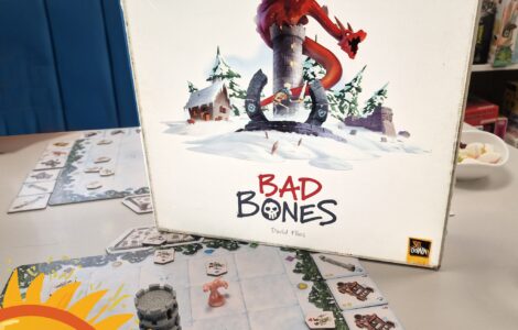 Board game "Bad Bones" by David Flies displayed on a table, featuring a colorful cover with a dragon and snowy landscape. Game pieces and cards are visible on the table, promoting the Summer Marathon 2024 event.