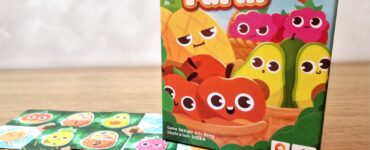 Colorful box of the game "Pocket Farm" featuring cute fruit characters, surrounded by game cards on a wooden table, with a banner indicating "54 Summer Marathon 2024."