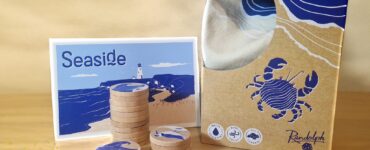 Seaside board game by Bryan Burgoyne featuring colorful game pieces and packaging, displayed alongside a promotional card for the Summer Marathon 2024 event.